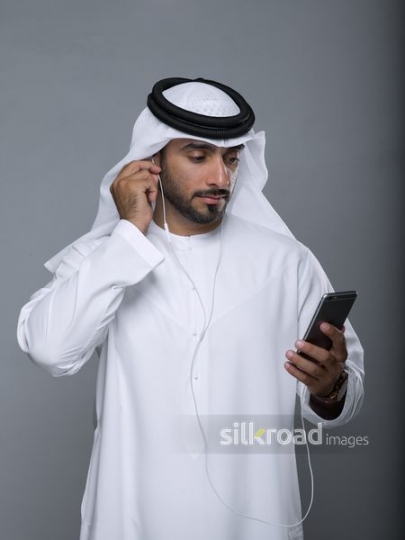 Arabian man fixing his earphones