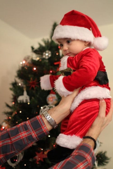 Newborn baby with Santa Hat, held by his father