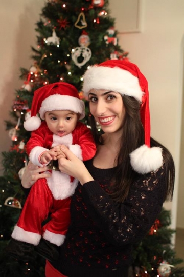 Newborn baby with Santa Hat, held by his mother