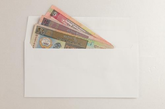 kuwaiti dinars in an envelope