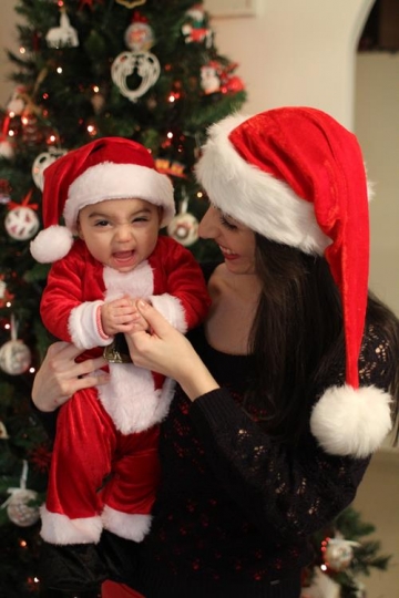Newborn baby with Santa Hat, held by his mother