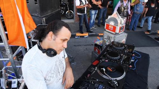 photo of adult dj working with his equipment
