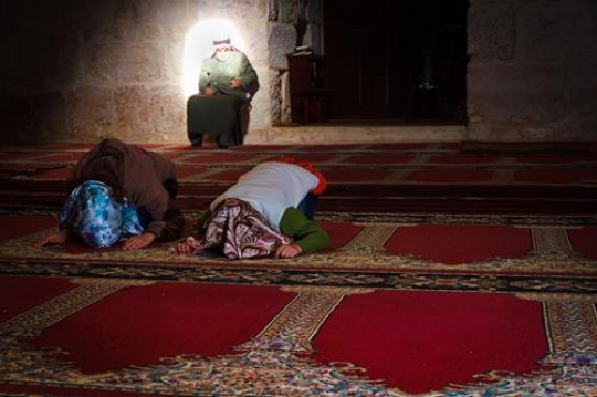 Two muslim girls and old man praying