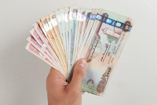 hands with uae dirham currency