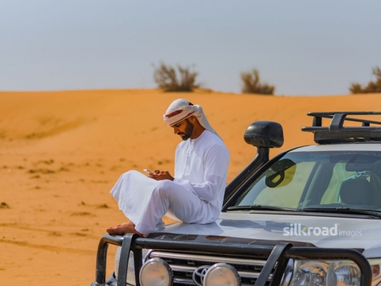 Man communicating on car trunk