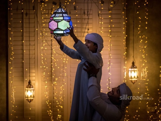 Father carrying son with lantern|-