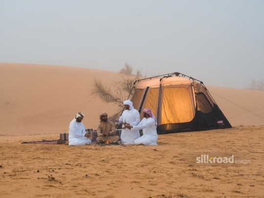 Friends warming up around fire