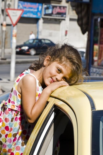 little girl sitting on a car window