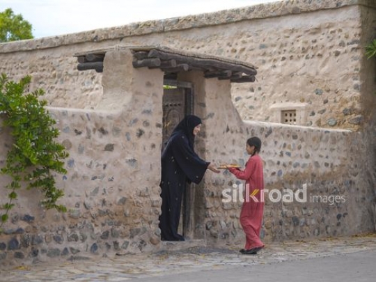 Woman taking plate from girl|-