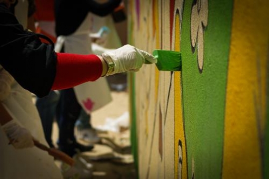 group of volunteer drawing on the wall of kindergarten