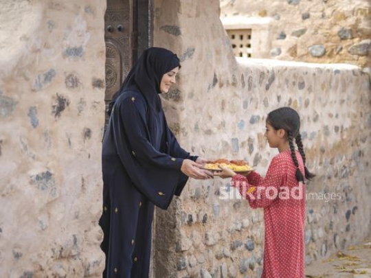 Woman taking plate from little girl|-