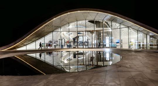 Futuristic Dubai Building at Night with Reflective Pool
