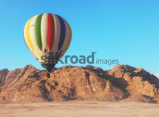 Hot Air Balloon Soaring Over Wadi Rum Desert Landscape