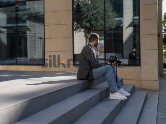 Joyful Photographer on Steps with Camera in Amman Boulevard