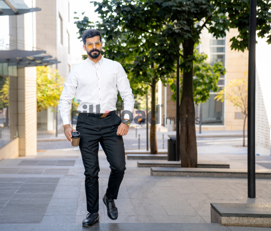 Man Walking Between Modern Buildings with Coffee Cup in Al Abdali Boulevard