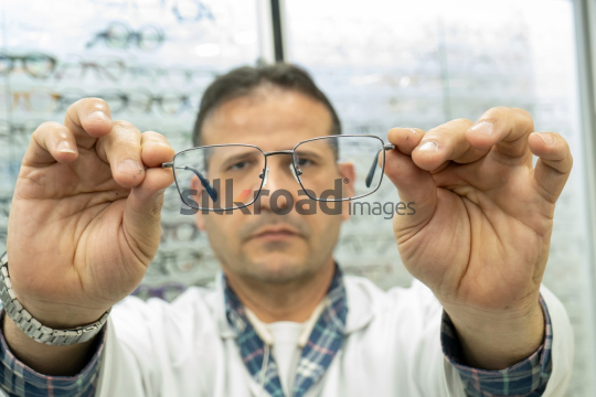 Optometrist Inspecting Sunglasses for Clarity