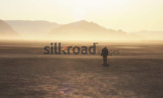 Person Walking in Wadi Rum Desert at Sunrise