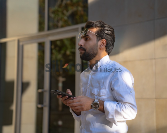 Professional Man Walking Past Glass Door in Morning Light at Al Abdali Boulevard
