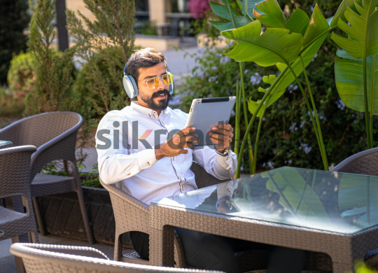 Professional Man with Headset on Zoom Call, Working on iPad at Desk with Coffee and Sunglasses