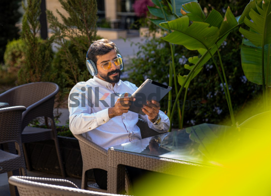 Professional Man with Headset on Zoom Call, Working on iPad at Desk with Coffee and Sunglasses