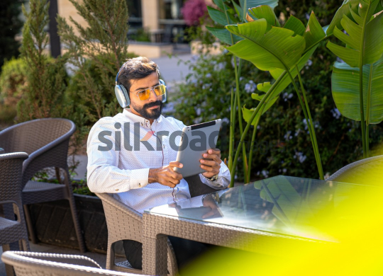 Professional Man with Headset Working on iPad at Desk