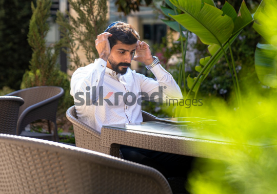 Professional Man with Headset Working on iPad at Desk