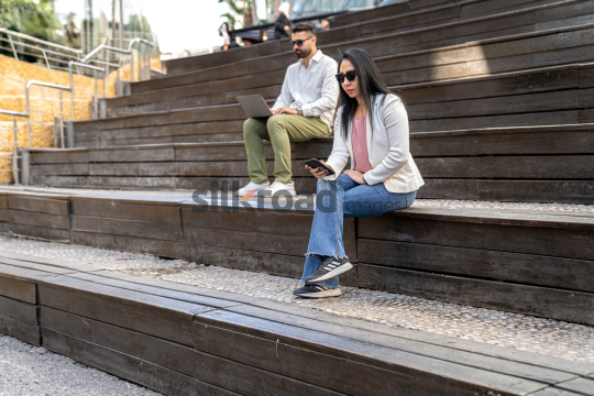 Professional Woman and Man Working in Modern Outdoor Setting at Amman’s Abdali Boulevard