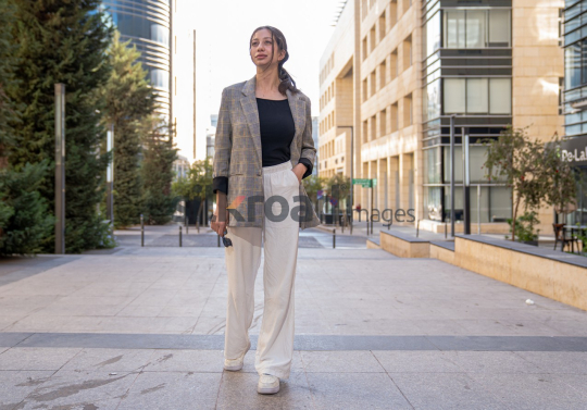 Professional Woman Contemplating Business in the Modern Setting of Al Abdali, Amman Boulevard