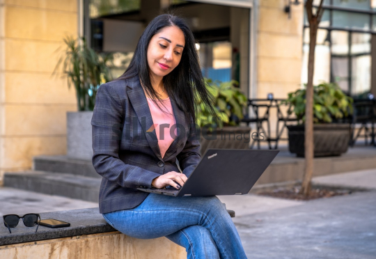 Professional Woman Problem-Solving on Laptop in Al Abdali Boulevard