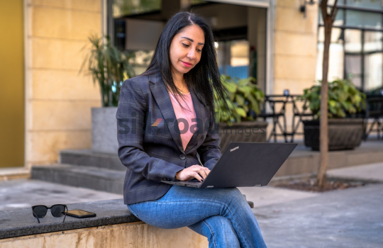 Professional Woman Problem-Solving on Laptop in Al Abdali Boulevard