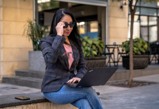 Professional Woman Working on Laptop with Sunglasses in Al Abdali Boulevard