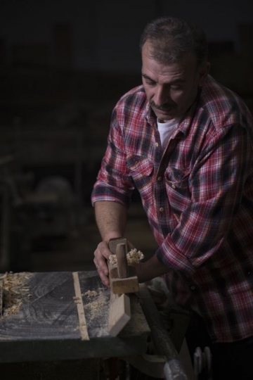 European man cleaning the wood