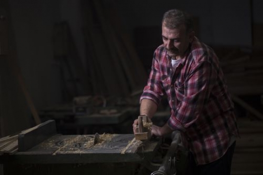 European man cleaning the wood