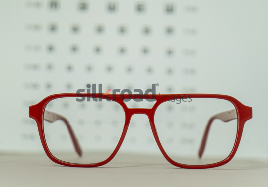 Red Eyeglasses in Front of Eye Chart