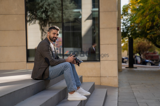 Smiling Photographer on Steps with Camera in Amman Boulevard