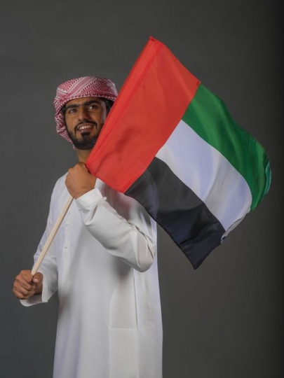 Emirati man carrying a flag