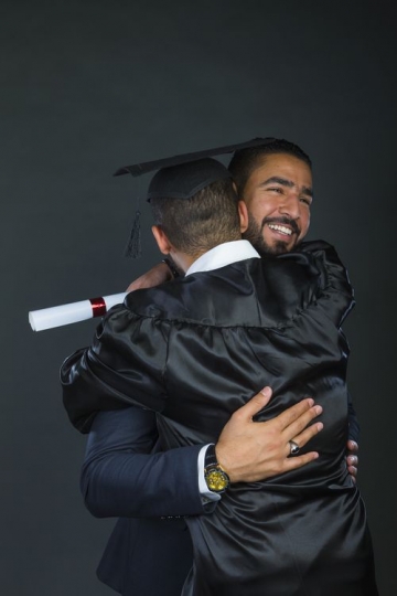 Graduated son hugging his father