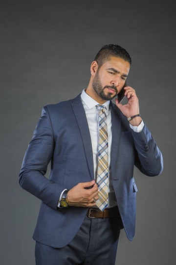 businessman in a suit speaking over the phone|-