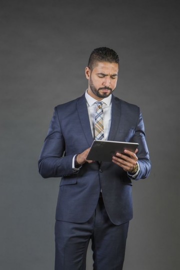 Middle Eastern Businessman using device|-