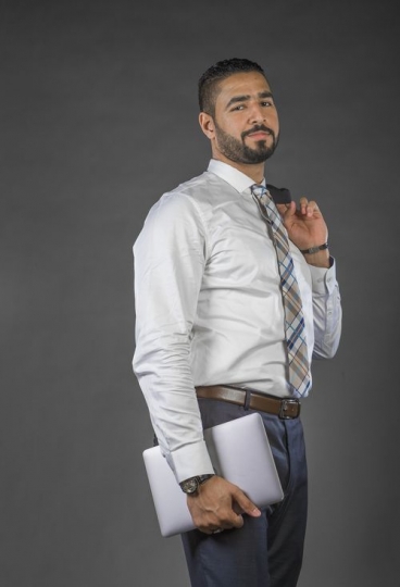 Businessman carrying laptop and smiling|-