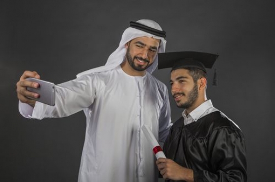 Middle Eastern father taking a selfie with his son