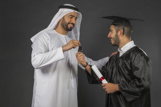 Middle Eastern father gifting his son on graduation 