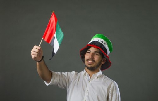Man waving flag around celebrating the UAE National Day