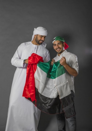 Friends holding onto the UAE Flag