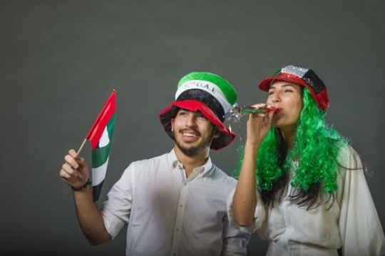 Arab man and Arab woman excited celebrating the UAE National Day