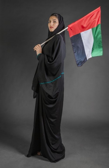 Middle Eastern woman carrying the UAE National Day flag