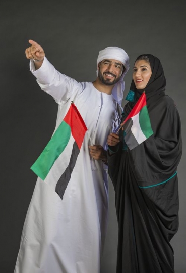Man pointing showing something to the Woman carrying the UAE flags