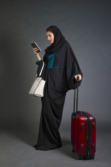 Middle Eastern Businesswoman standing and using her mobile|-