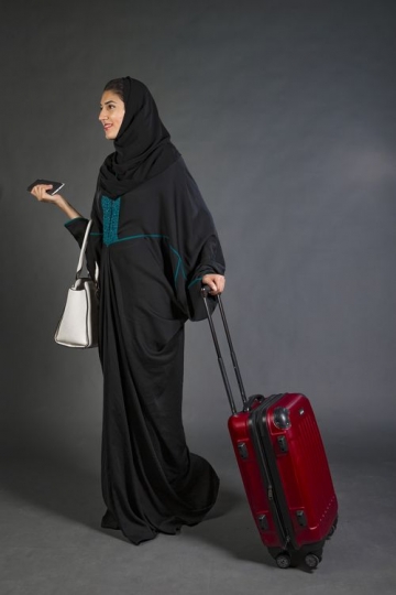 Middle Eastern Businesswoman walking with carry on|-