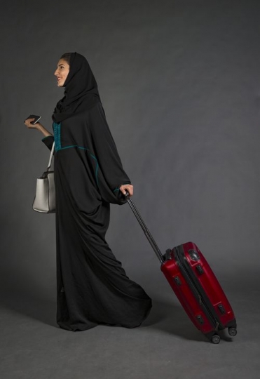 Businesswoman walking with luggage|-